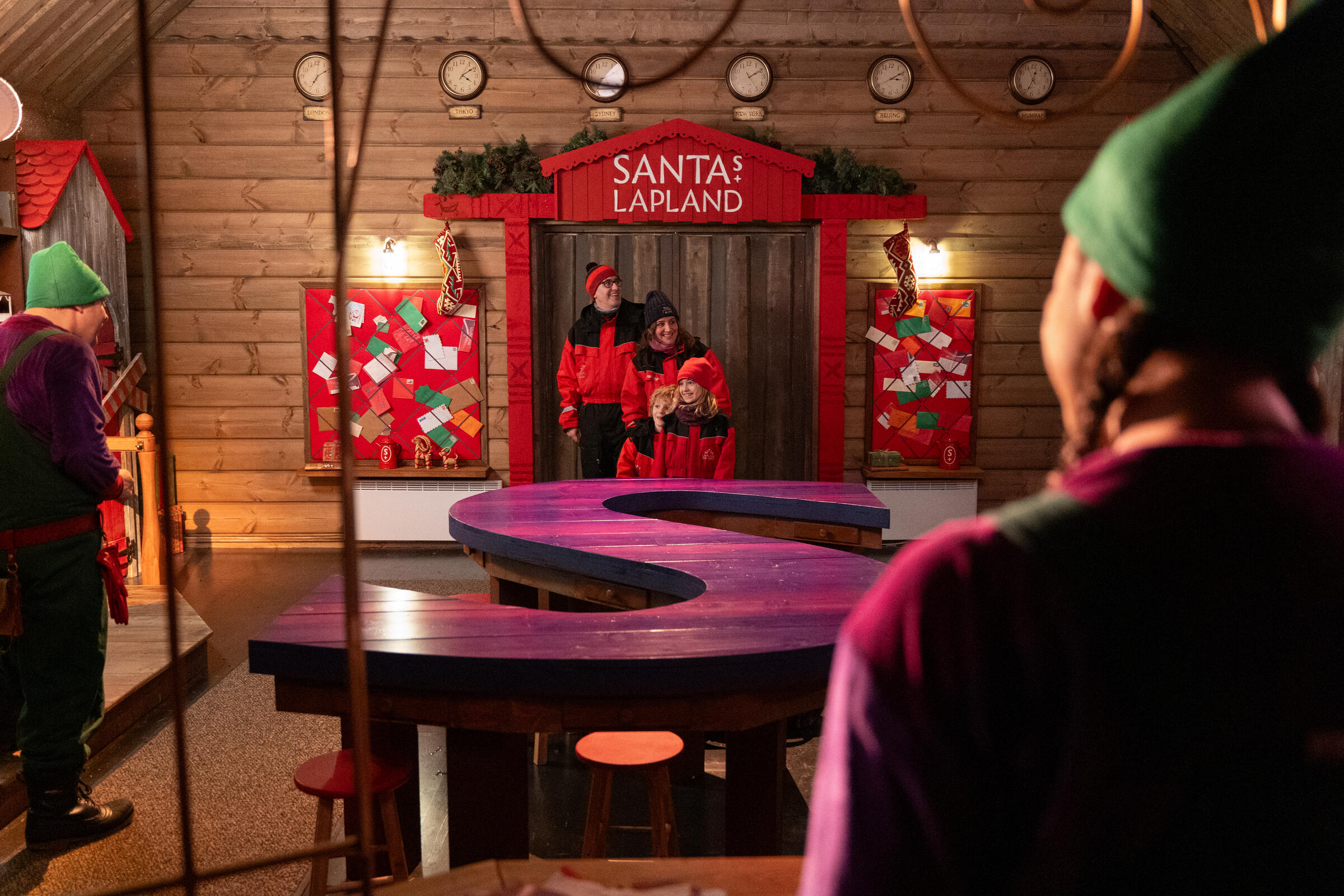 Family meeting elves inside their cosy workshop during a family trip to Lapland.