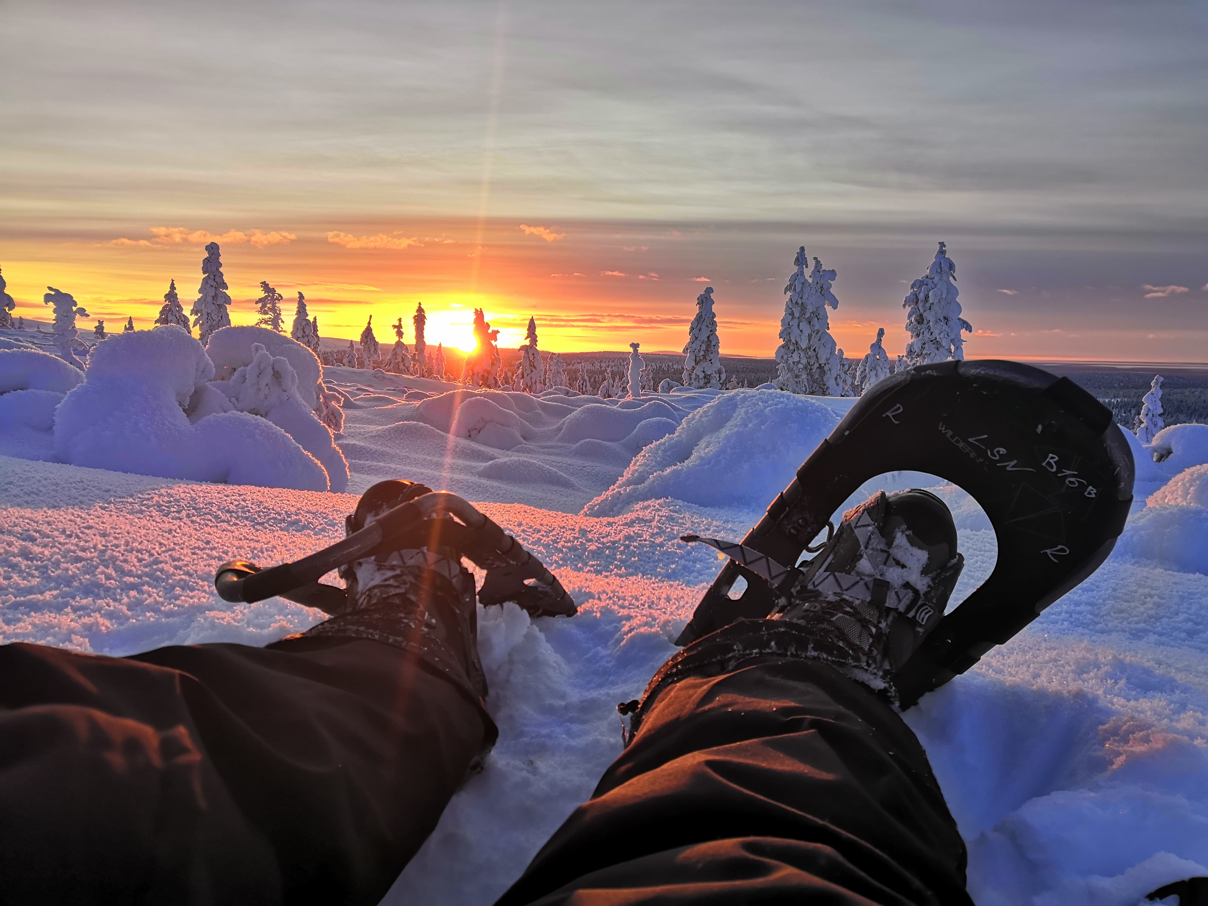 family Lapland snowshoeing at sunset in Saariselkä