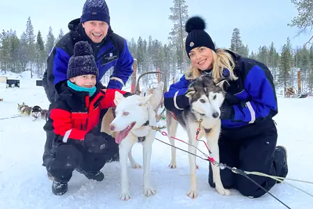 Family posing with huskies
